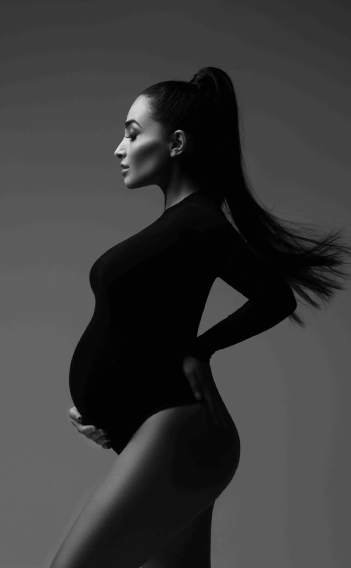 Black-and-white fashion maternity portrait of a woman in profile