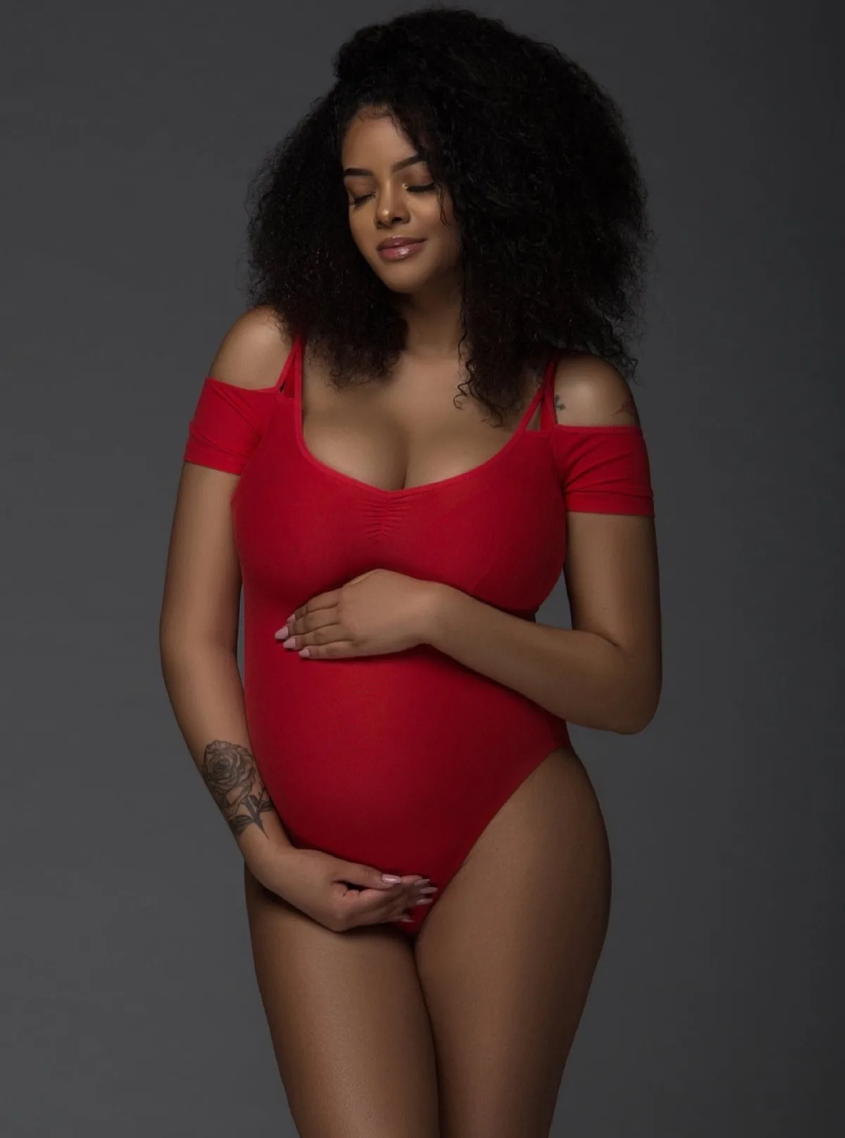 Pregnant woman in a red bodysuit for a Chicago maternity photoshoot
